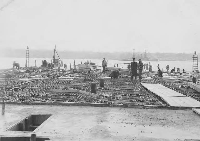 Workers handling steel reinforcement rebar at a construction stockyard