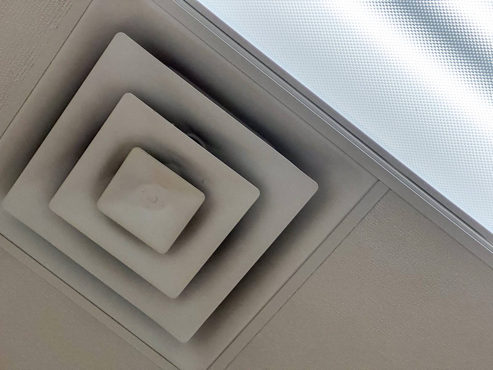 Drop ceiling grid with HVAC diffuser and lighting cutouts in a commercial office
