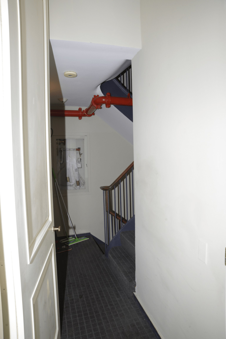 Fire safety equipment in a building hallway near an emergency exit, relevant to fire compartmentation requirements