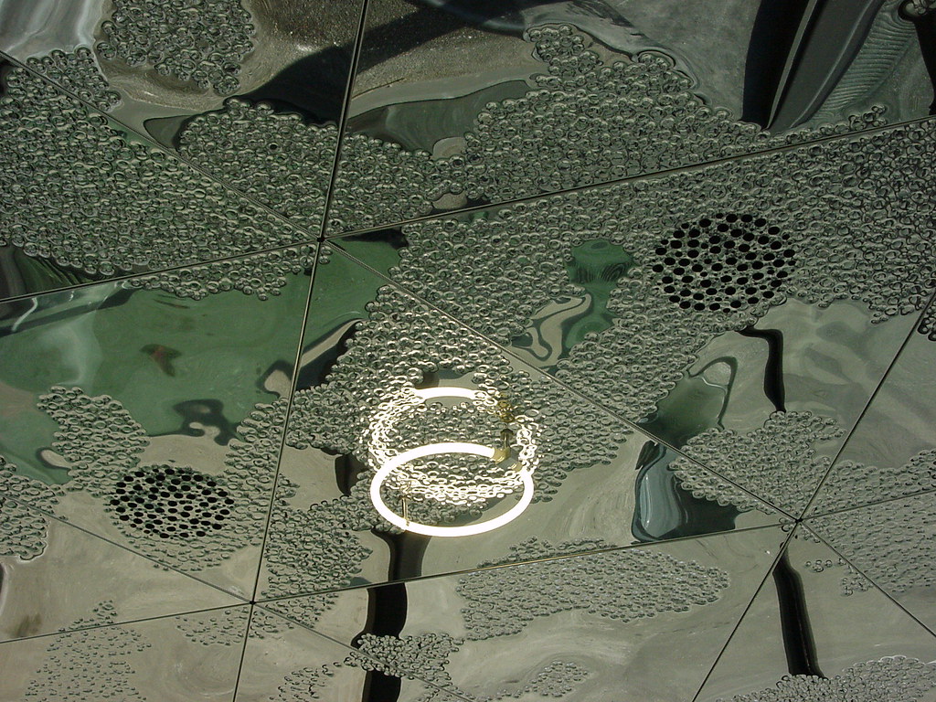 Perforated metal acoustic ceiling panels installed in a modern UAE office meeting room