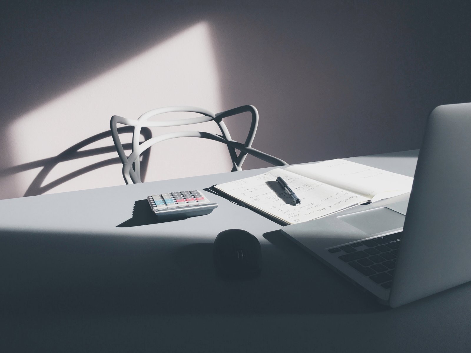 Desk with a laptop, notebook and calculator representing a small UAE business starting its ERPNext accounting setup